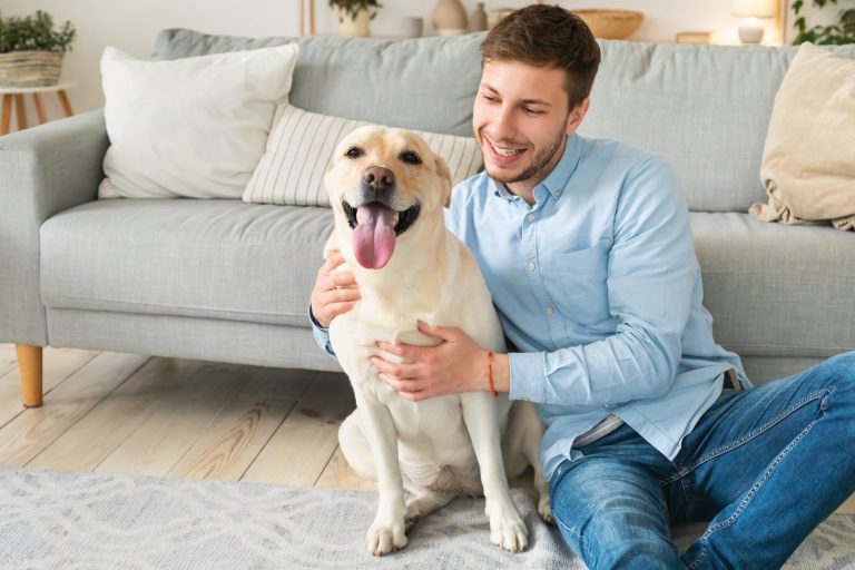 young-happy-man-hugging-dog-sitting-on-floor.jpg